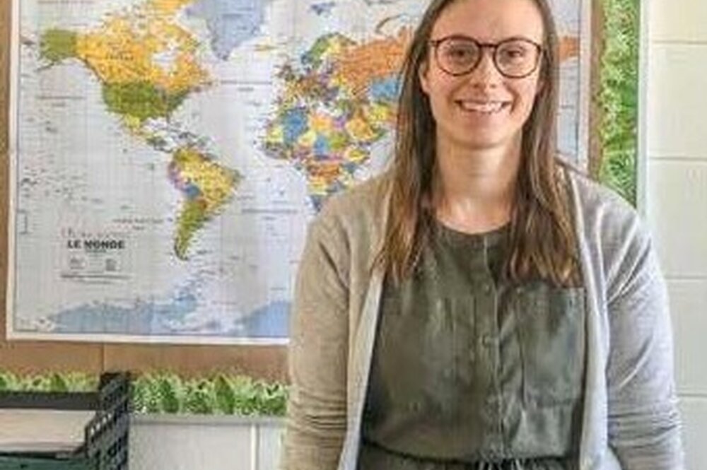 Headshot of Laura Furrer in front of world map